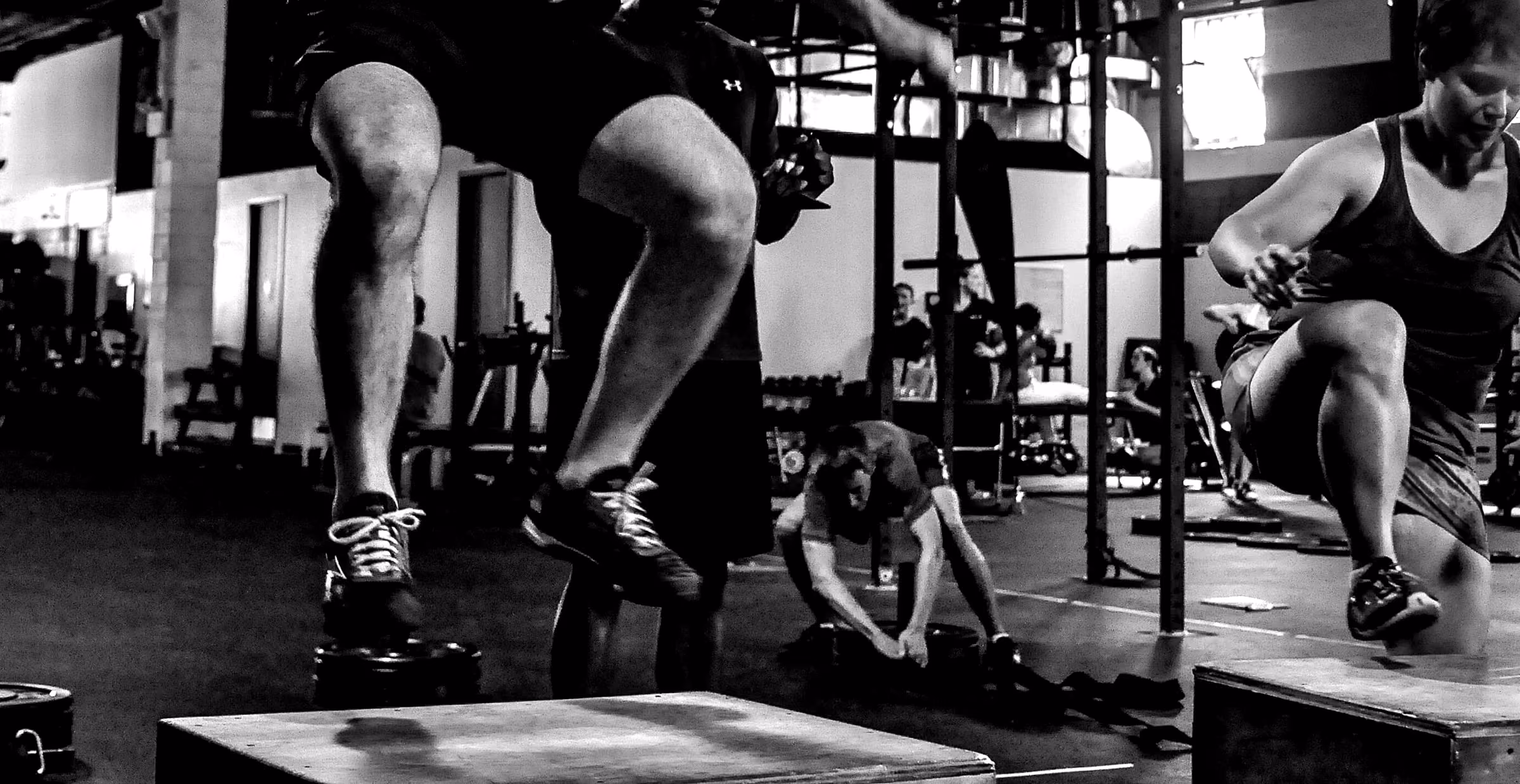 Salto al cajón durante una clase de crossfit, vista a la altura de las piernas