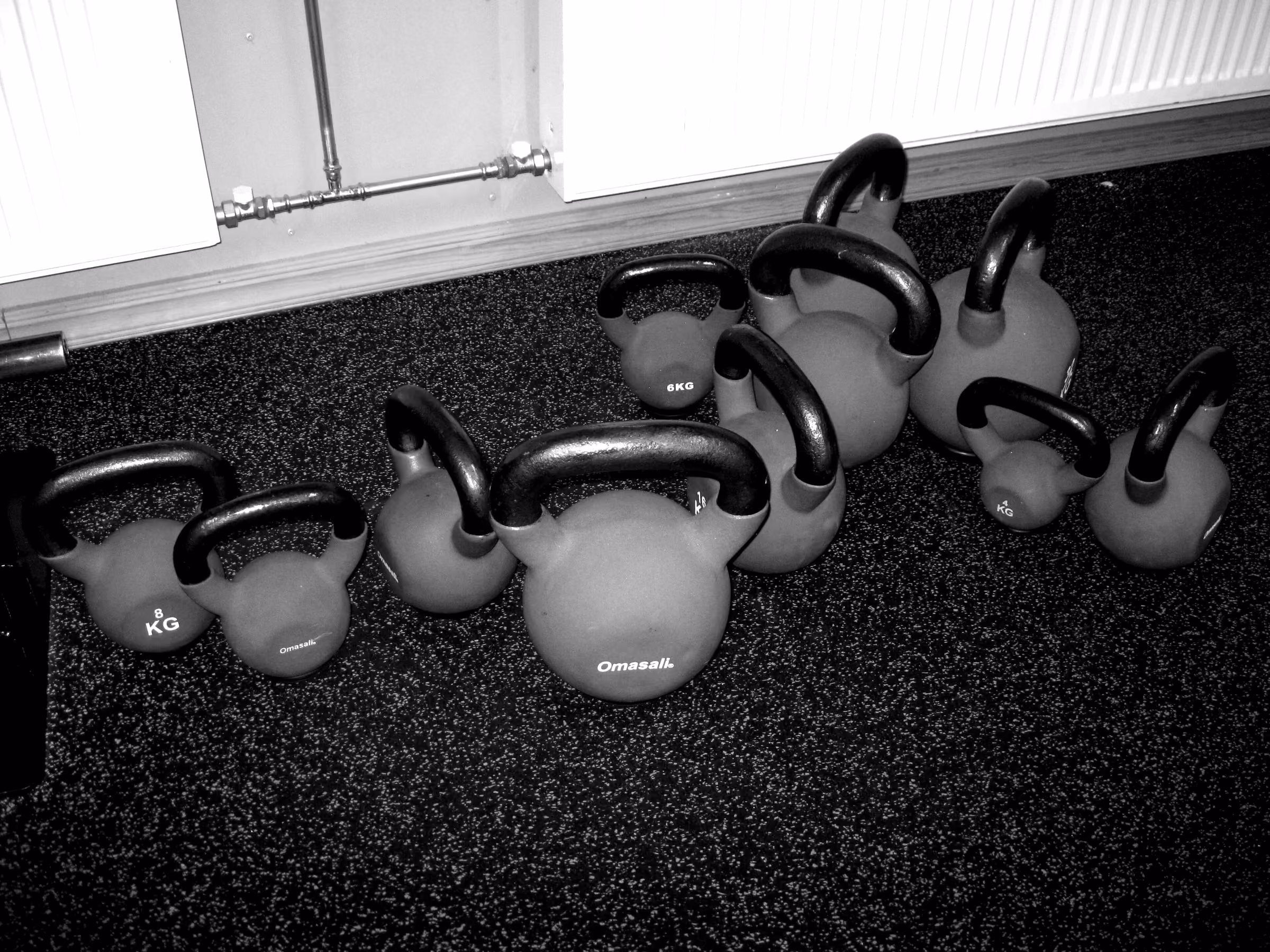 Kettlebells de distintos pesos sobre piso de goma